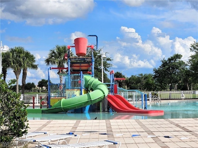 communal playground featuring a water play area, a community pool, and fence