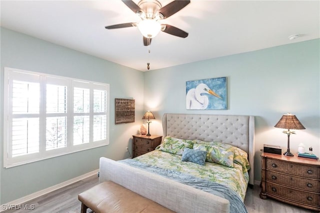 bedroom featuring baseboards, a ceiling fan, and wood finished floors