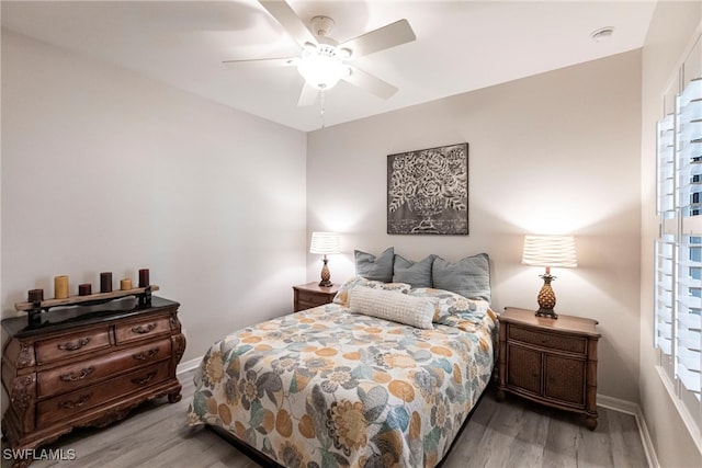bedroom featuring baseboards, a ceiling fan, and wood finished floors