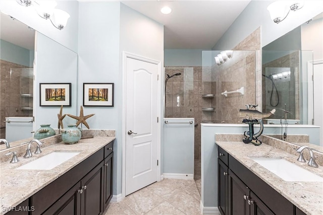 bathroom with two vanities, a tile shower, and a sink