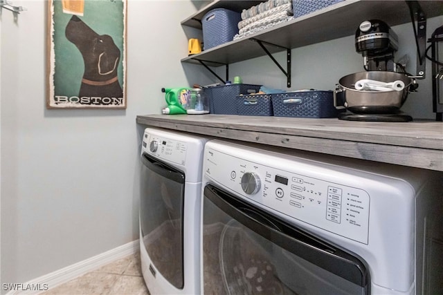 laundry room with baseboards, laundry area, light tile patterned flooring, and washer and clothes dryer