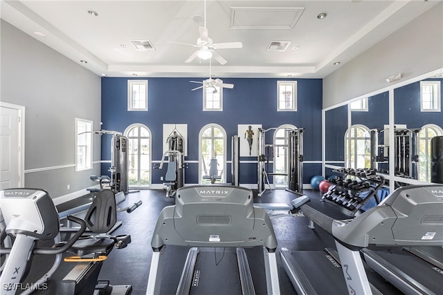 workout area with visible vents, a towering ceiling, and ceiling fan