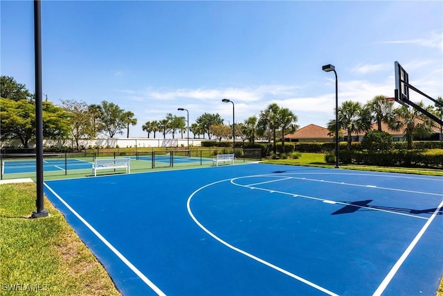 view of sport court featuring a tennis court, fence, and community basketball court