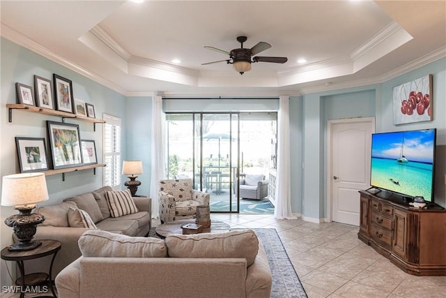 living room with crown molding, a tray ceiling, and ceiling fan