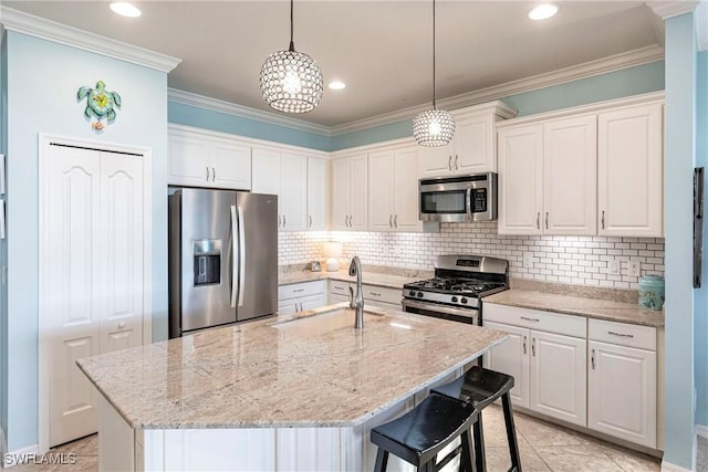 kitchen featuring white cabinets, appliances with stainless steel finishes, ornamental molding, and a sink