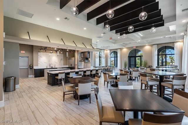 dining room with recessed lighting, beamed ceiling, light wood-type flooring, and visible vents