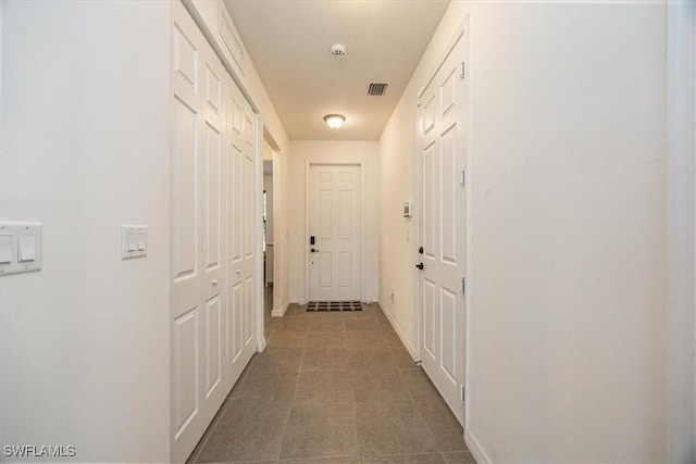 hall featuring visible vents and baseboards