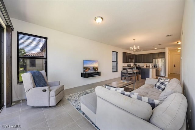 living room with an inviting chandelier, light tile patterned floors, and visible vents