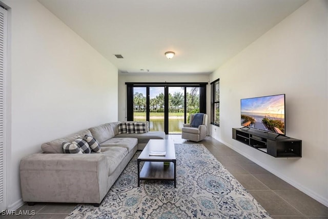 tiled living room featuring baseboards and visible vents