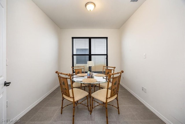 dining area with baseboards and tile patterned flooring