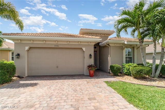 view of front of home featuring stucco siding, an attached garage, driveway, and a tile roof