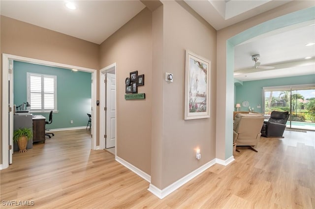 hall featuring baseboards, recessed lighting, and light wood finished floors