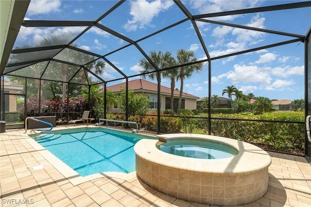 view of pool featuring a patio, glass enclosure, and a pool with connected hot tub