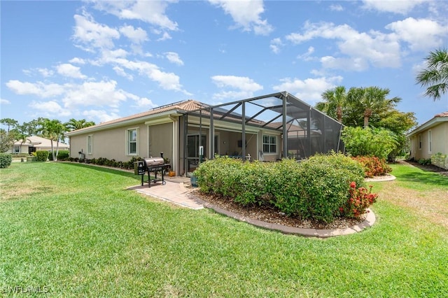 rear view of property featuring a lawn, a patio area, a lanai, and stucco siding