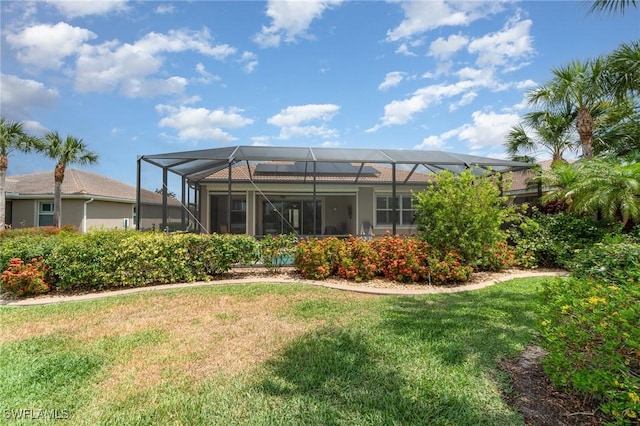back of property with a lawn and glass enclosure