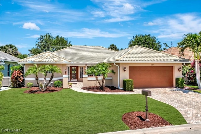 ranch-style home with an attached garage, a front lawn, stucco siding, and a tile roof