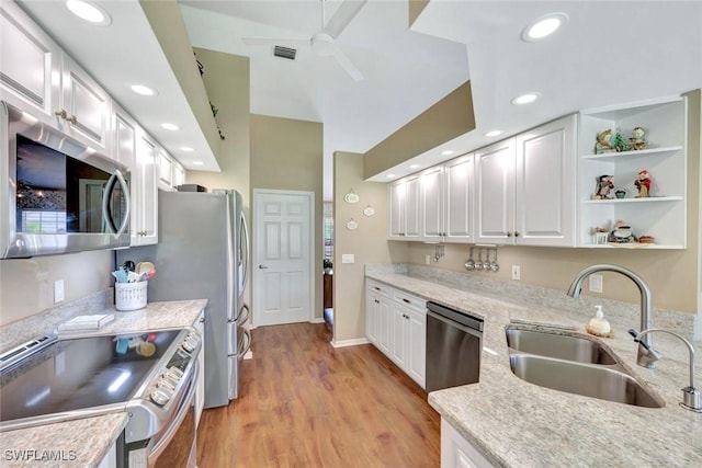 kitchen with visible vents, appliances with stainless steel finishes, a sink, light wood finished floors, and white cabinetry