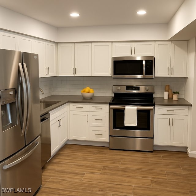 428 Meadowlark Ln Unit A, Naples, FL 34105 - kitchen featuring a sink, white cabinetry, dark countertops, and stainless steel appliances