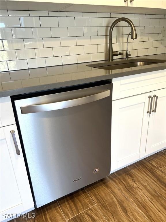 428 Meadowlark Ln Unit A, Naples, FL 34105 - interior details featuring white cabinets, dark countertops, a sink, dishwasher, and backsplash