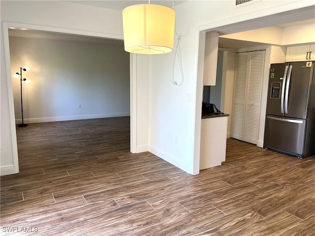 428 Meadowlark Ln Unit A, Naples, FL 34105 - kitchen featuring visible vents, dark countertops, stainless steel fridge with ice dispenser, baseboards, and dark wood-type flooring