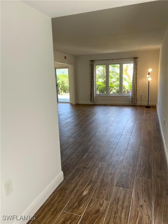 428 Meadowlark Ln Unit A, Naples, FL 34105 - spare room featuring baseboards and dark wood finished floors