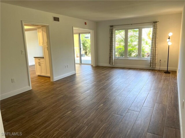 428 Meadowlark Ln Unit A, Naples, FL 34105 - unfurnished living room with baseboards, visible vents, and dark wood-style floors