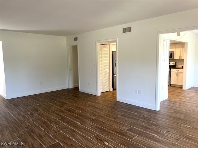 428 Meadowlark Ln Unit A, Naples, FL 34105 - empty room with visible vents, baseboards, and dark wood-style floors