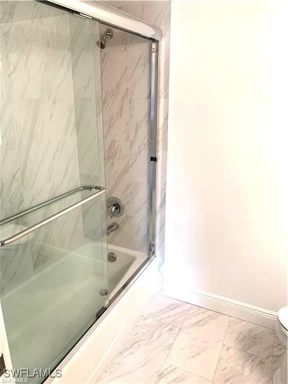 428 Meadowlark Ln Unit A, Naples, FL 34105 - bathroom with shower / bath combination with glass door, baseboards, toilet, and marble finish floor
