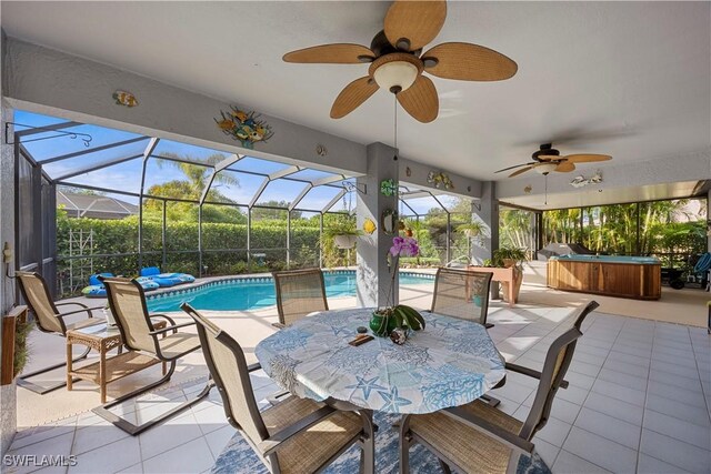view of patio with ceiling fan, an outdoor pool, and a hot tub