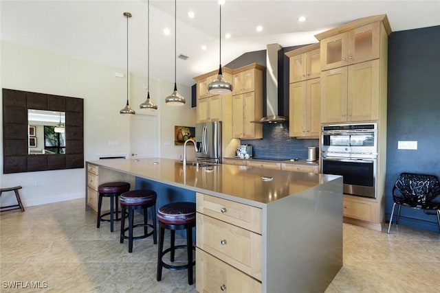 16591 Waters Edge Ct, Fort Myers, FL 33908 - kitchen featuring appliances with stainless steel finishes, light brown cabinets, wall chimney exhaust hood, decorative backsplash, and a spacious island