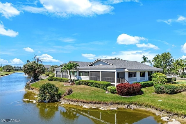 16591 Waters Edge Ct, Fort Myers, FL 33908 - rear view of property with a sunroom, a shingled roof, a lawn, and a water view
