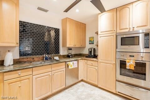 kitchen featuring stainless steel appliances, light brown cabinets, a warming drawer, and a sink