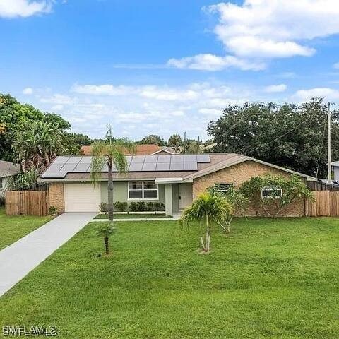 view of front of property featuring fence, a front lawn, and a garage