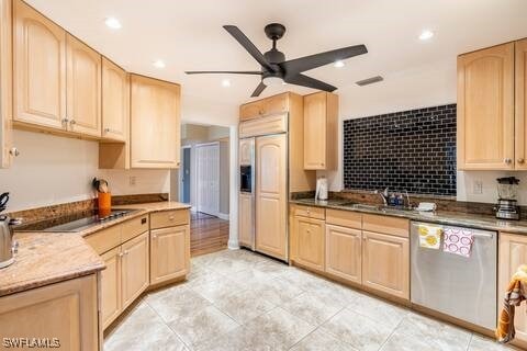 kitchen featuring paneled refrigerator, light brown cabinetry, dishwasher, a sink, and a ceiling fan
