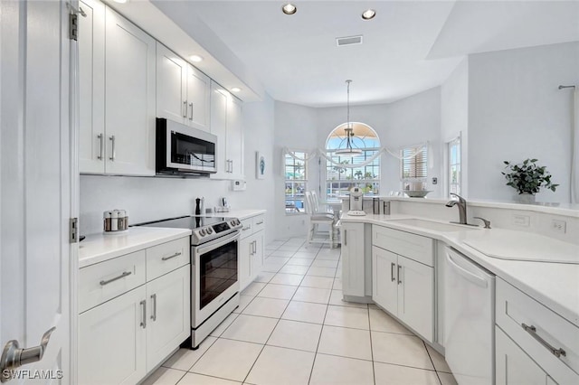 kitchen featuring appliances with stainless steel finishes, a sink, recessed lighting, light countertops, and light tile patterned floors