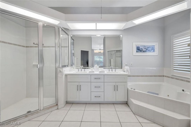 bathroom featuring a stall shower, a tub with jets, double vanity, and tile patterned flooring