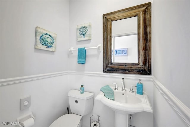 half bath featuring toilet and a sink
