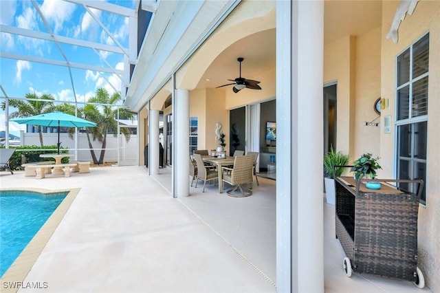 view of swimming pool featuring a patio, a lanai, fence, and ceiling fan
