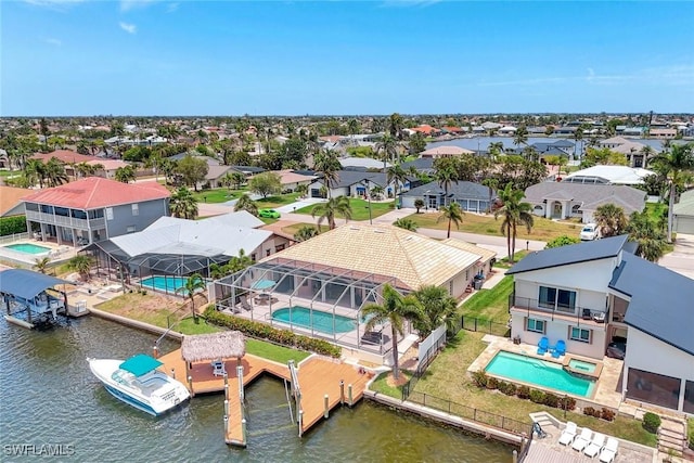 aerial perspective of suburban area featuring a pool area and a nearby body of water