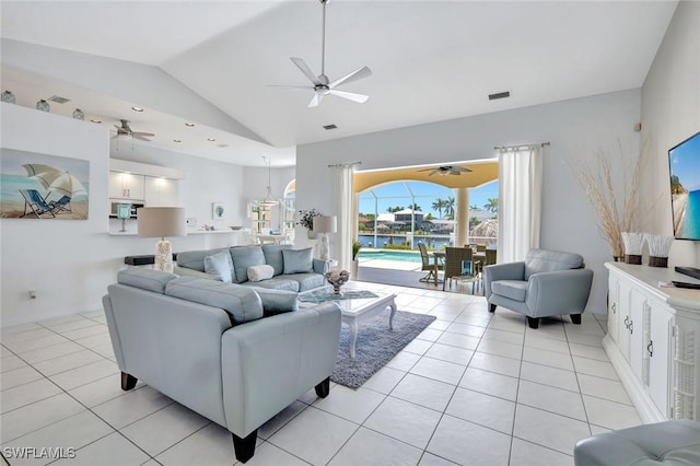 living area featuring ceiling fan, vaulted ceiling, and light tile patterned floors