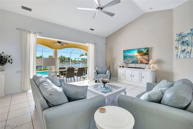 living room featuring ceiling fan, vaulted ceiling, light tile patterned floors, and baseboards