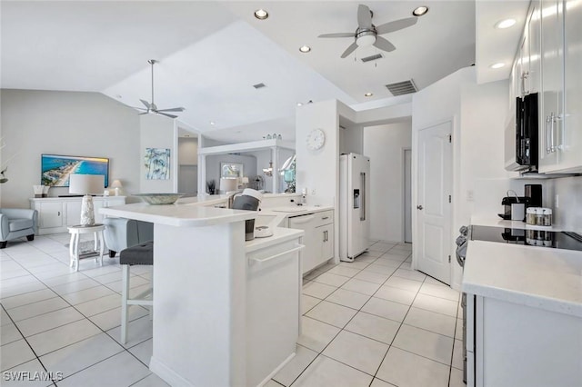 kitchen with ceiling fan, white appliances, open floor plan, a kitchen breakfast bar, and lofted ceiling