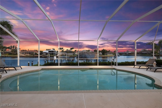 outdoor pool featuring a water view, a patio area, boat lift, and a lanai