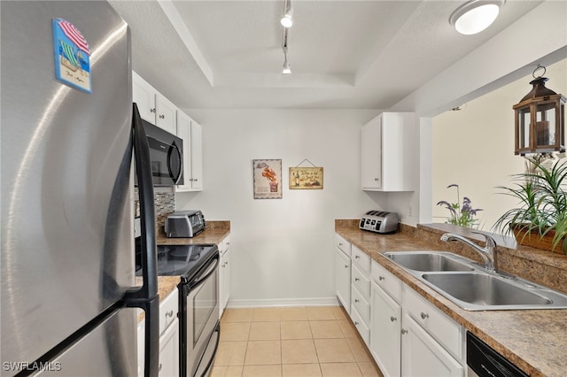 3330 N Key Dr Unit 6, North Fort Myers, FL 33903 - kitchen featuring white cabinets, appliances with stainless steel finishes, a sink, rail lighting, and a tray ceiling