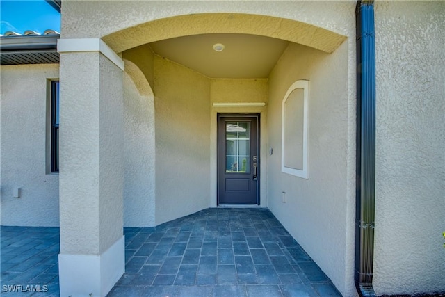 entrance to property featuring stucco siding