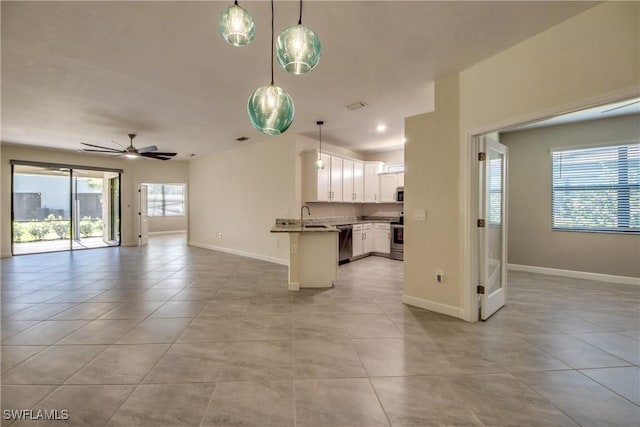interior space with stainless steel appliances, open floor plan, and light tile patterned floors