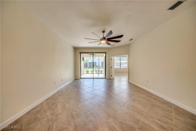 spare room with baseboards, a ceiling fan, light tile patterned floors, and visible vents
