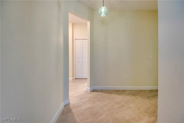 unfurnished room with baseboards