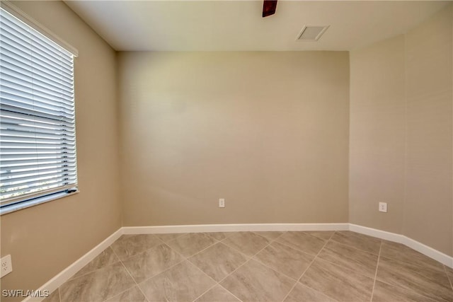 spare room featuring visible vents, baseboards, and light tile patterned floors