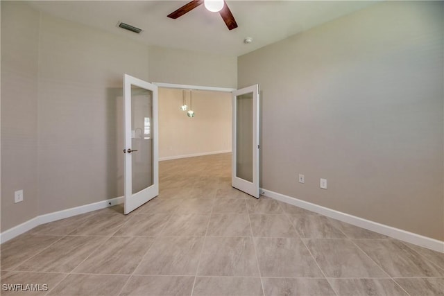 spare room featuring french doors, a ceiling fan, baseboards, and visible vents